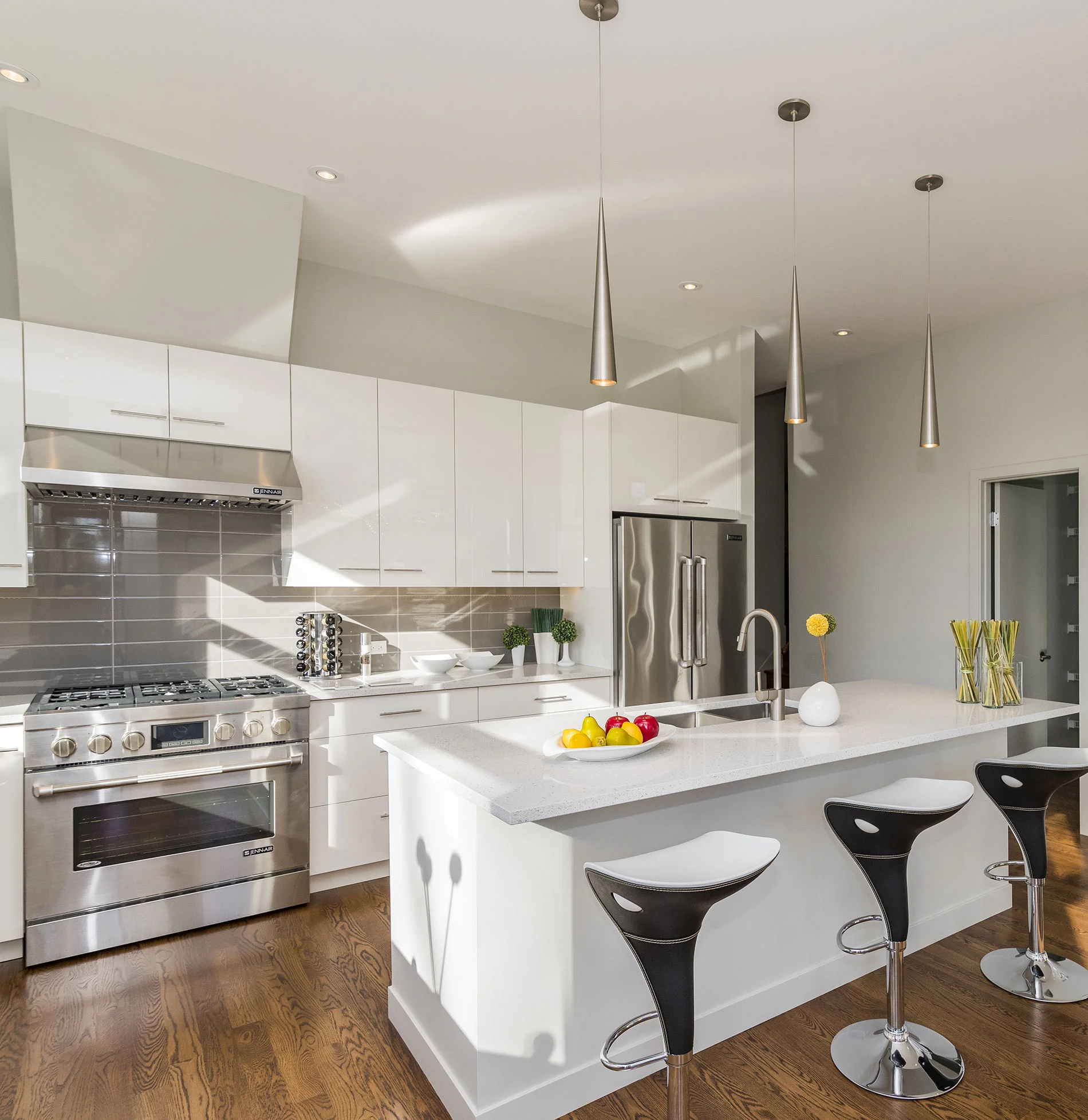 Modern kitchen with white cabinetry, stainless steel appliances, and a central island with bar stools in San Francisco.