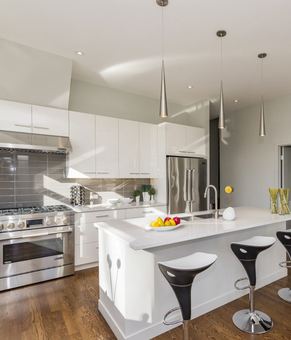 Modern kitchen with white cabinetry, stainless steel appliances, and a central island with bar stools in San Francisco.