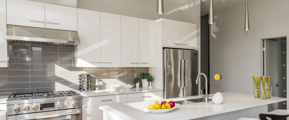 Modern kitchen with white cabinetry, stainless steel appliances, and a central island with bar stools in San Francisco.