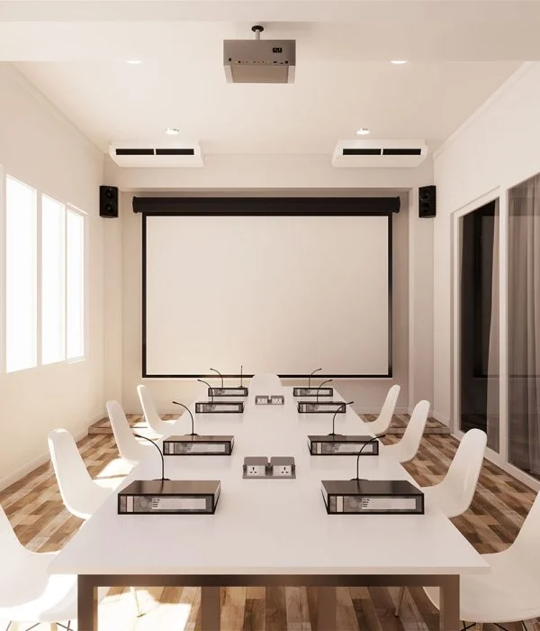 Modern conference room with commercial cleaning, a projector, screen, and sitting arrangement for meetings.